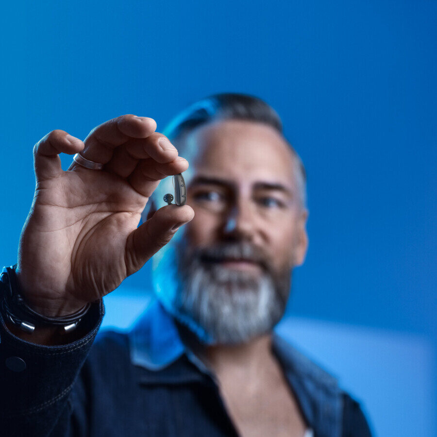 Signia_2021H12_older_man_holding_HA-e1762185847517